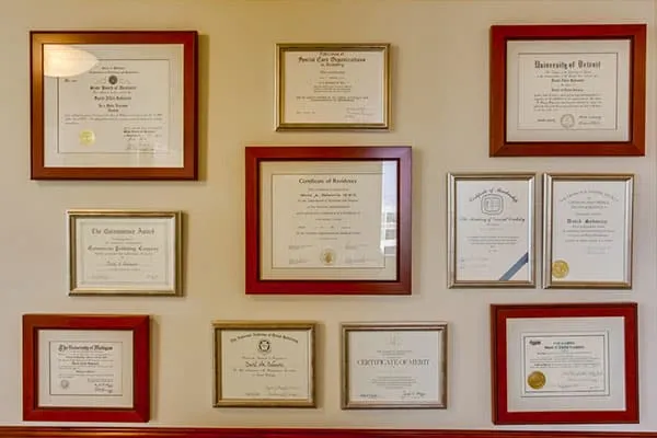A wall of Dr. Sabourin's framed diplomas and certificates