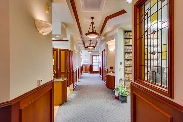 Office hallway with cherry wood trim, stained glass and pendant lights